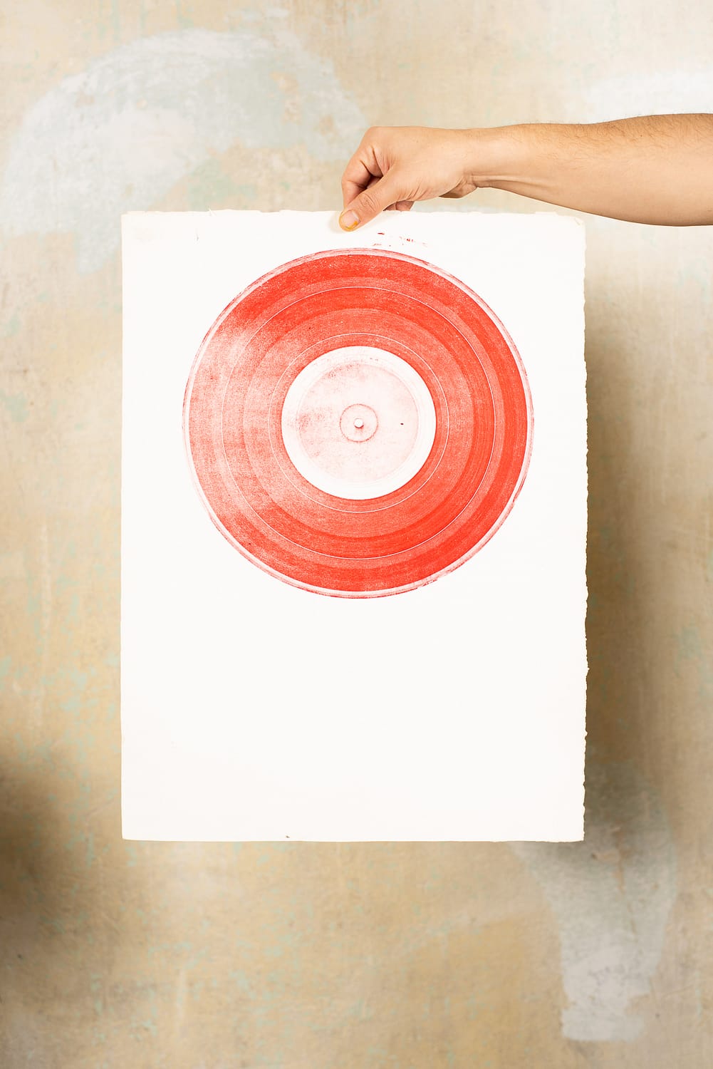 Hand hält Lithographie Druck mit Schallplatte in Rot