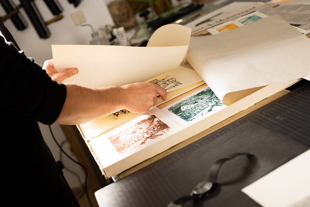 Two hands organise a box with prints