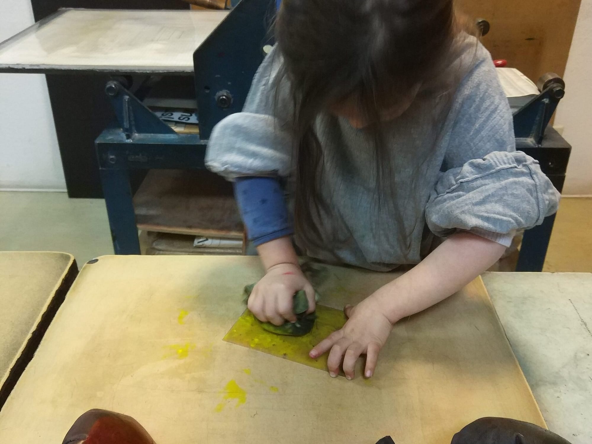 Kind druckt Farbe in einer radierte Kunststoff-Platte